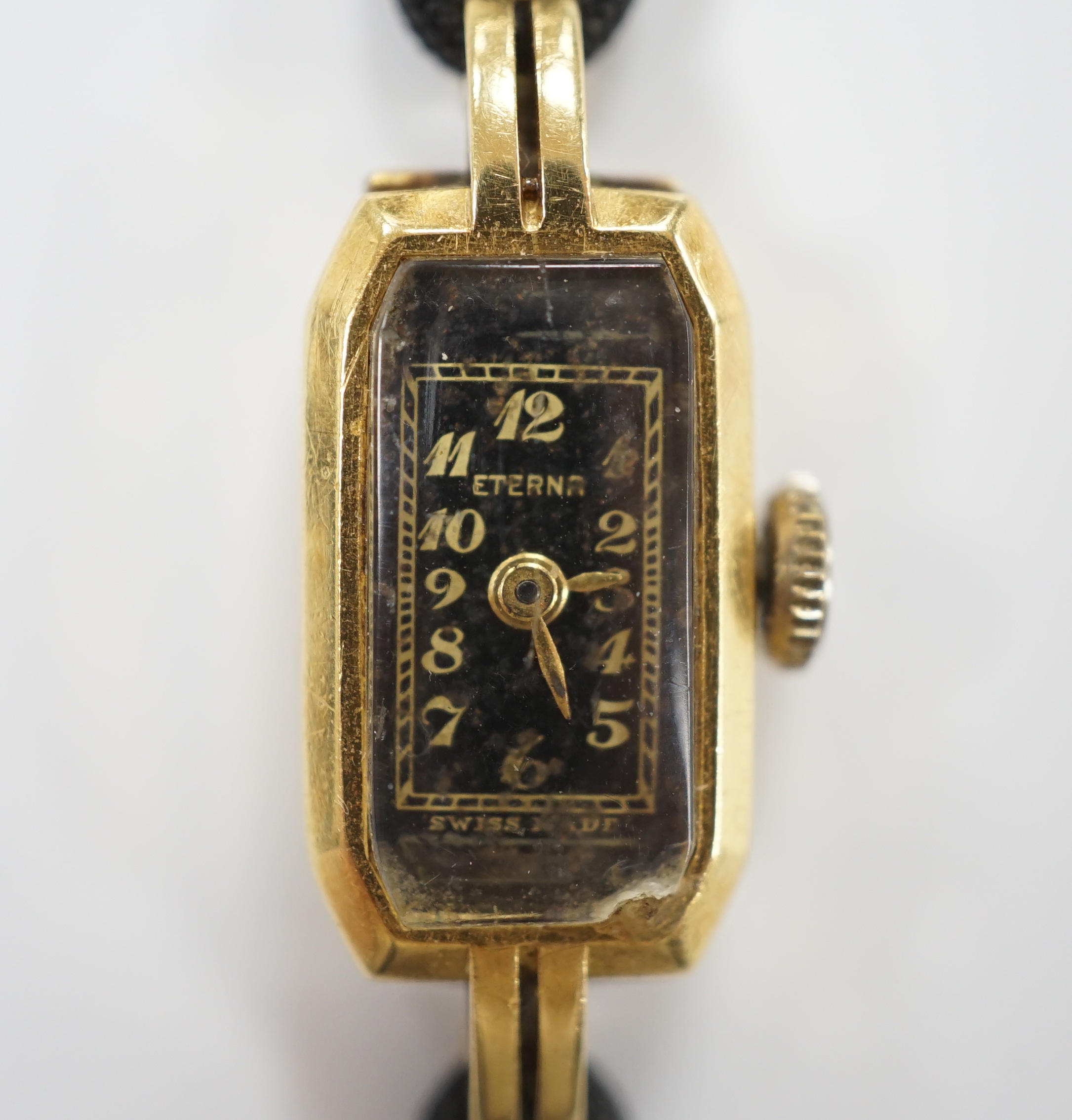 A lady's 1930's 18ct gold Eterna manual wind wrist watch, on a twin strand fabric strap with gold plated clasp